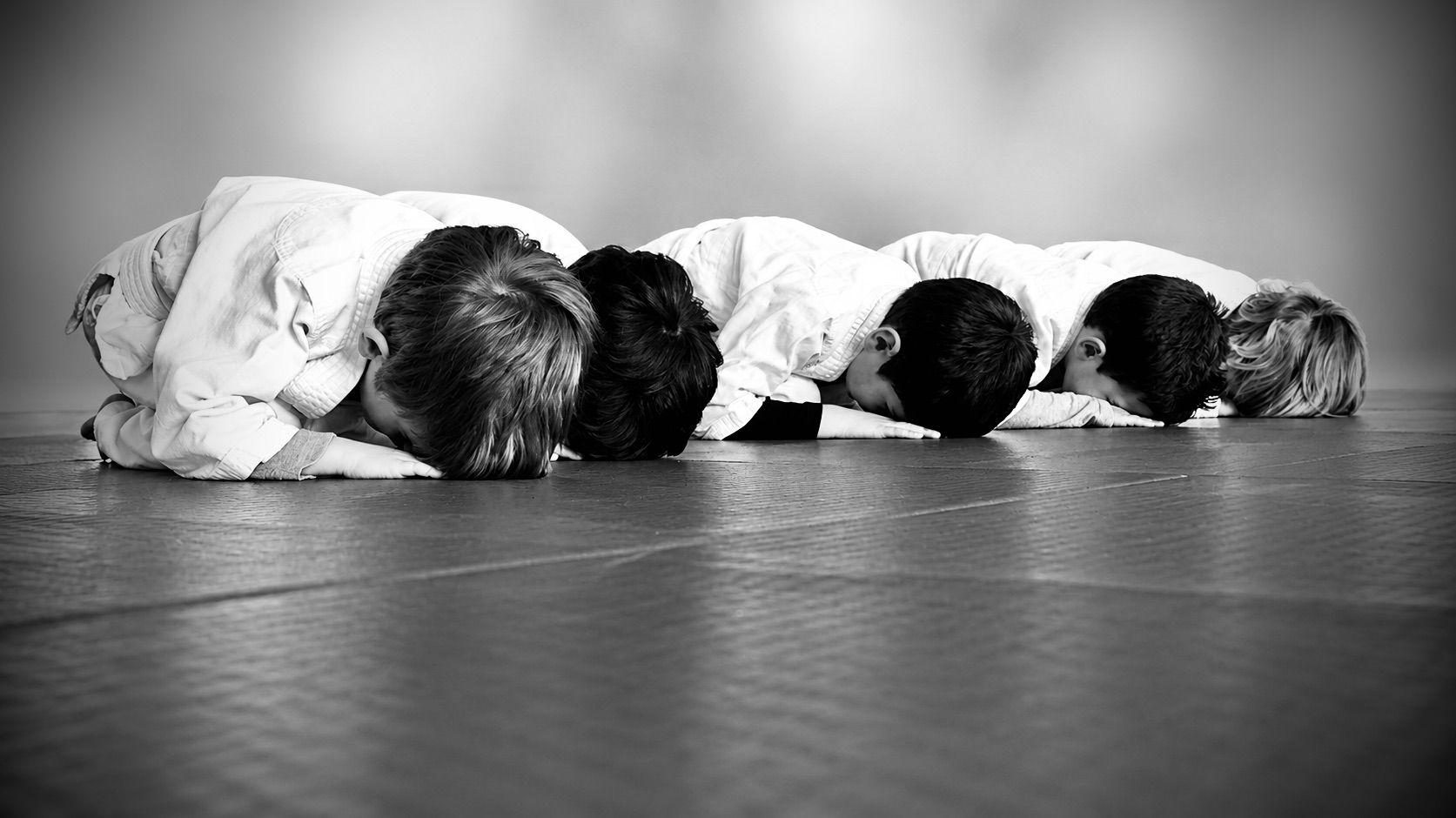 Des enfants s’entraînent à deux pendant un cours d’aikido
