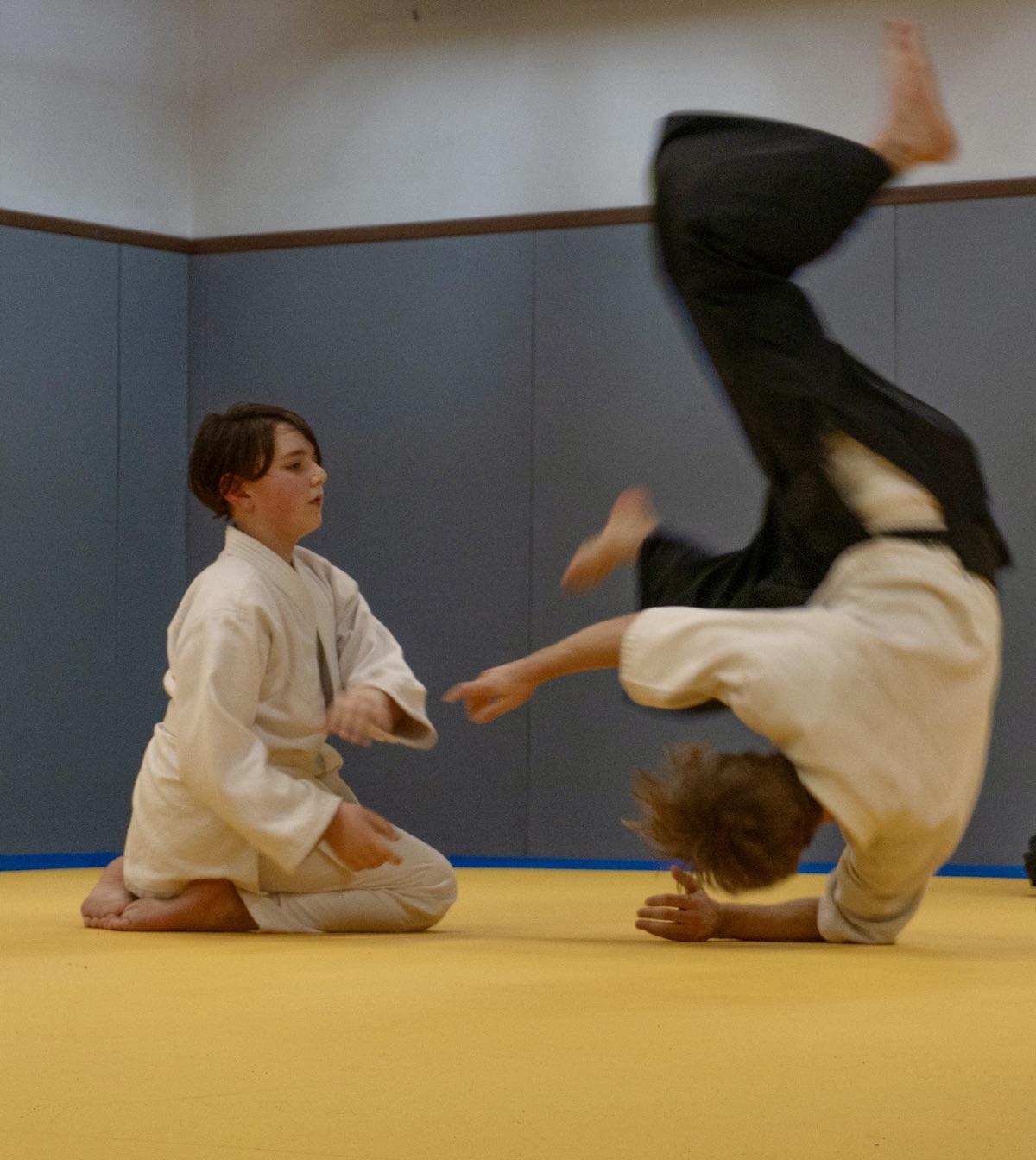 Un enfant pratique une technique d’aikido avec un partenaire au dojo